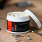 Cbd chamois cream, open on a workbench showing the creamy product in the tub