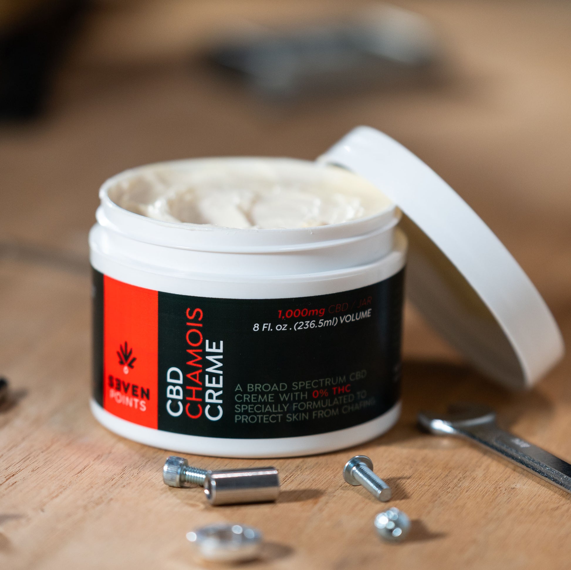 Cbd chamois cream, open on a workbench showing the creamy product in the tub